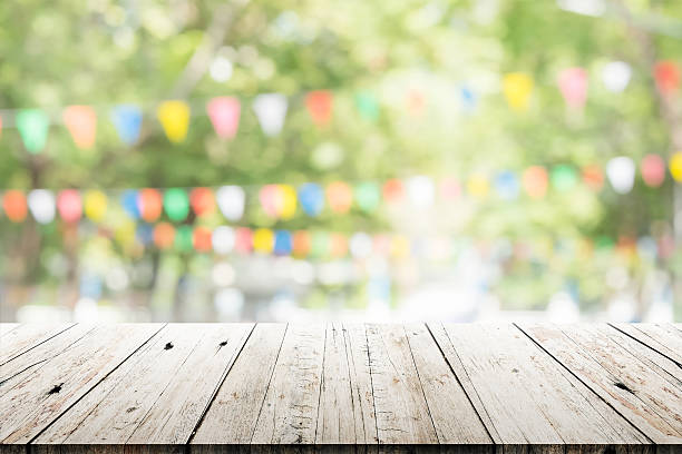 Empty wooden table with blurred party on background stock photo
