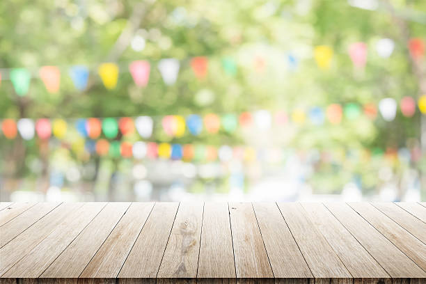 Empty wooden table with blurred party on background stock photo