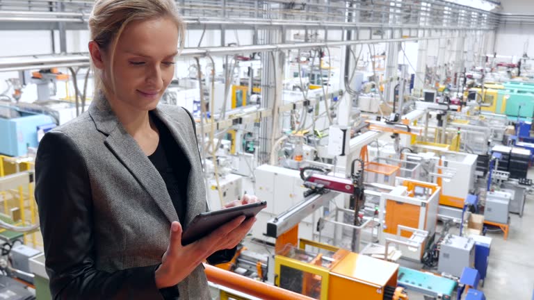 Beautiful businesswoman working on tablet in futuristic factory