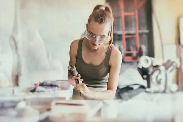 Photo of Young woman stonemason in her workshop