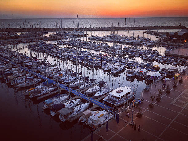 Herzliya, Israel  - May 10, 2016: Herzliya Marina at sunset, Israel. Boats, yachts and people walking.