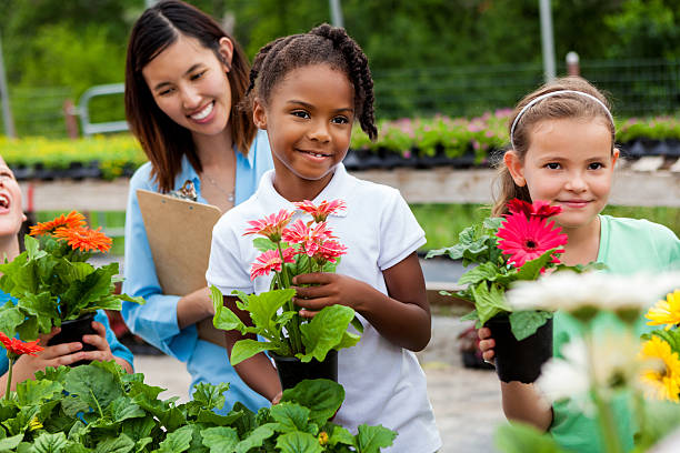 istock Two girl students holding flowers at nursery 540200480