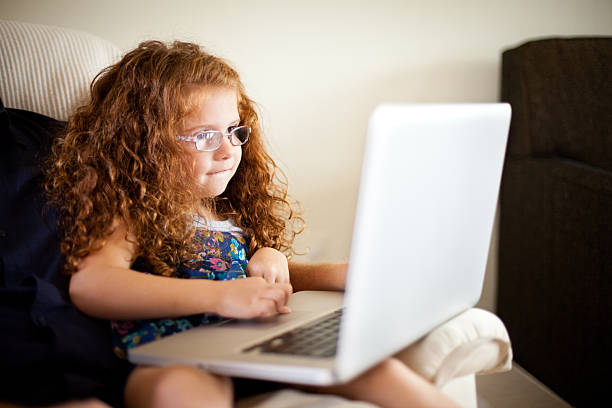 małe czerwone-haired za pomocą laptopa dziewczyny komputera w domu, - glasses child red hair little girls zdjęcia i obrazy z banku zdjęć