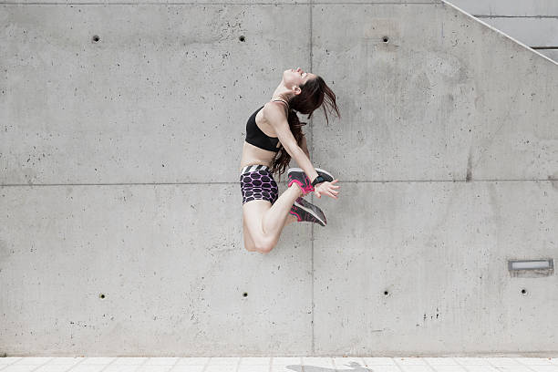 istock Woman jumping against concrete wall 540202128