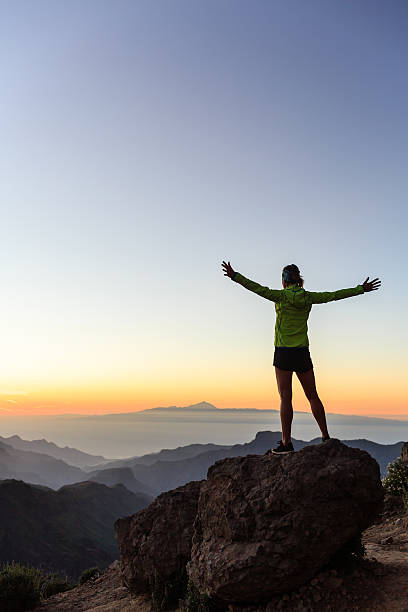 Woman climber success silhouette in inspiring mountains stock photo