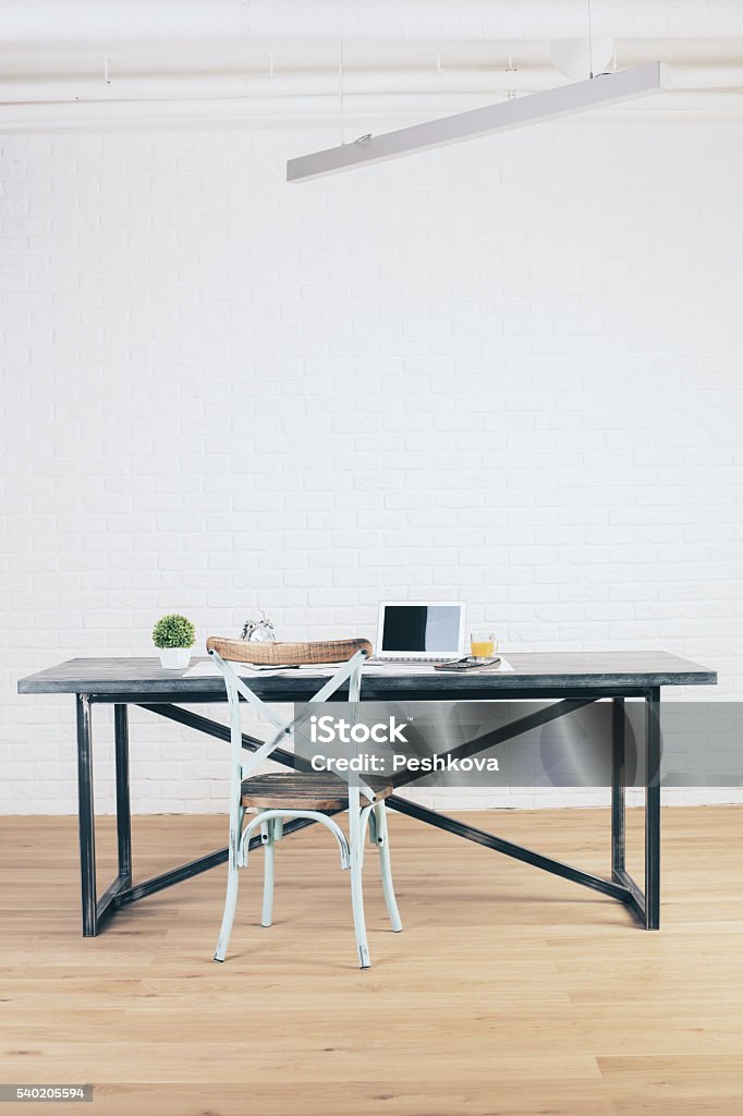 Workplace in room Workplace with antique chair in room with wooden floor and white brick wall Blank Stock Photo