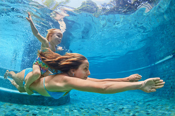 mother, baby girl swim and dive underwater in pool - baby swim under water bildbanksfoton och bilder