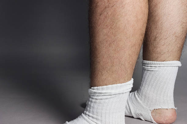 istock standing feet with white socks and a big hole 540209574