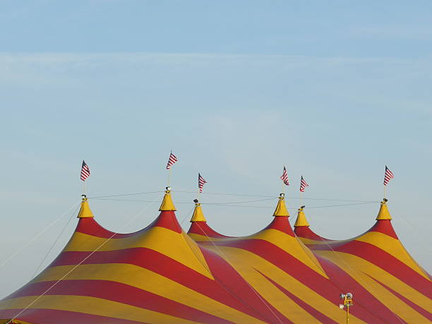 istock Big Circus Tent Top Blue Sky Flags Yellow Red Stripes 540213270
