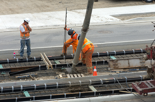 Kitchener, Ontario, Canada - June 13, 2016: Workers prepare rail track for pouring of cement during light rail transit line construction in Kitchener, Ontario. 