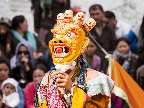 Monk performs a religious mask dance of Tibetan Buddhism Lamayuru, India - June 17, 2012: unidentified monk performs a religious masked and costumed mystery dance of Tibetan Buddhism during the Cham Dance Festival in Lamayuru monastery, India. cham mask stock pictures, royalty-free photos & images