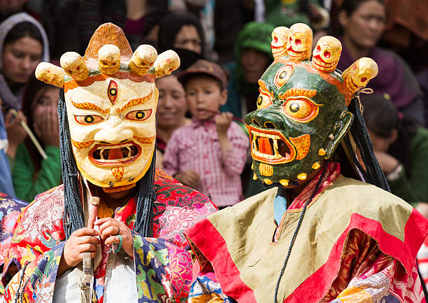 Monks perform a sacred mask dance of Tibetan Buddhism Lamayuru, India - June 17, 2012: unidentified monks perform a religious masked and costumed mystery dance of Tibetan Buddhism during the Cham Dance Festival in Lamayuru monastery, India. cham mask stock pictures, royalty-free photos & images