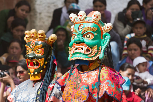 Monk performs a religious mask dance of Tibetan Buddhism Lamayuru, India - June 17, 2012: unidentified monk performs a religious masked and costumed mystery dance of Tibetan Buddhism during the Cham Dance Festival in Lamayuru monastery, India. cham mask stock pictures, royalty-free photos & images