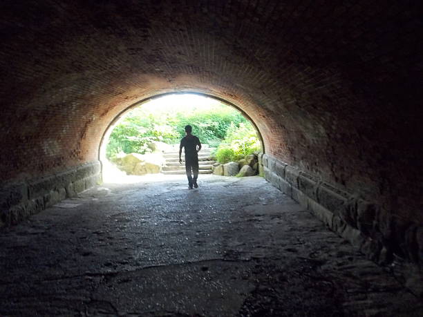 istock Lone Figure Walking Through Tunnel 540221268