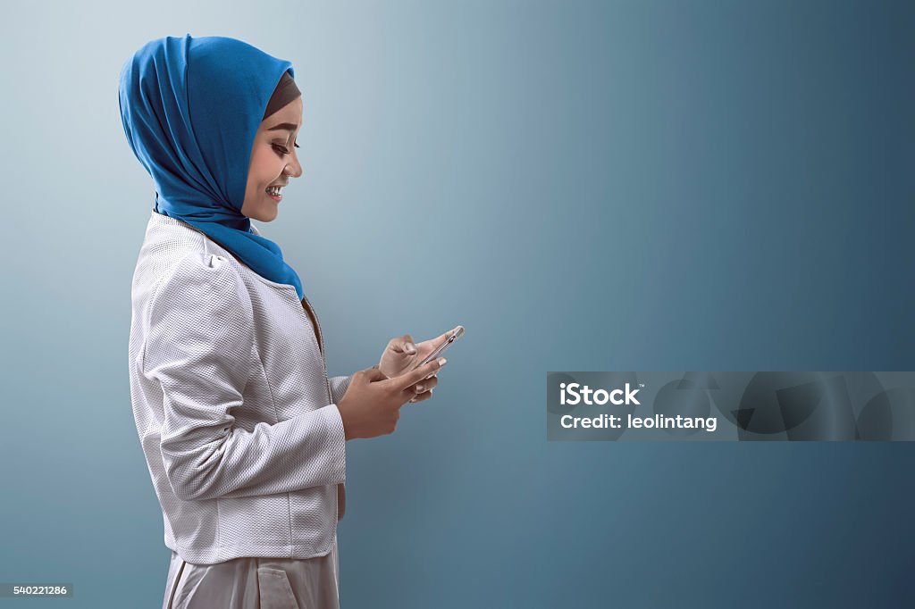Muçulmanos mulher digitando em um celular - Foto de stock de Mulheres royalty-free