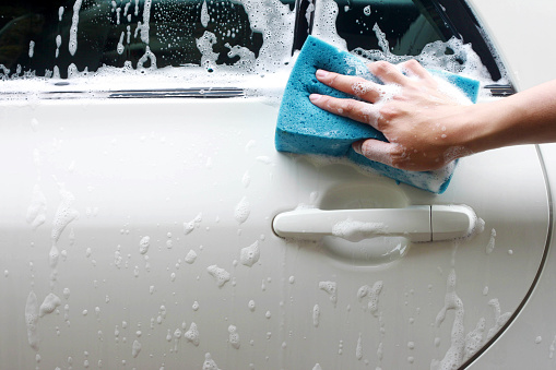 Hand hold sponge over the car for washing