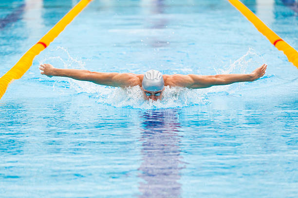 istock dynamic and fit swimmer in cap breathing performing the butterfly 540226050