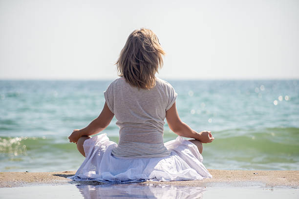 istock Woman meditating at the sea 540226778