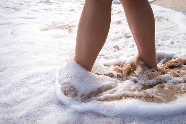 acercamiento de una mujer caminando en un revelador cuadrados de playa - barefoot behavior toned image close up fotografías e imágenes de stock