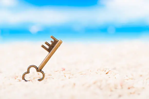 Key placed on the sandy beach