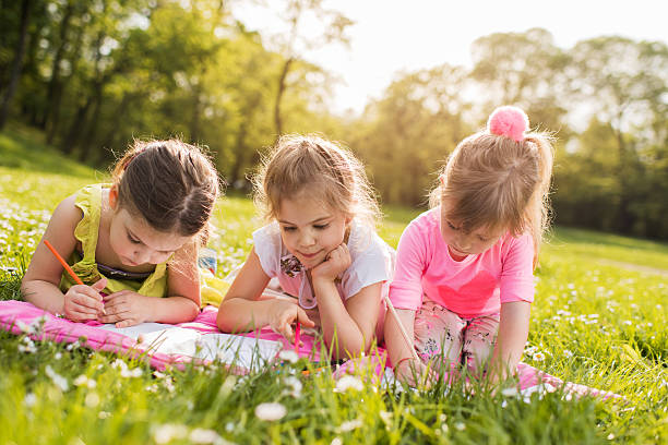 istock Cute little friends drawing while relaxing in the park. 540232462