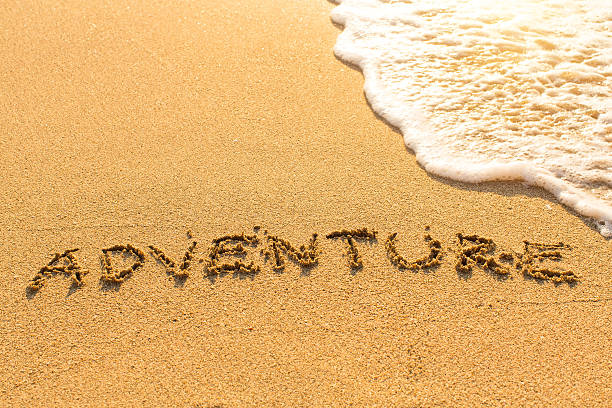 istock Adventure - inscription on sand beach with the soft wave. 540235520