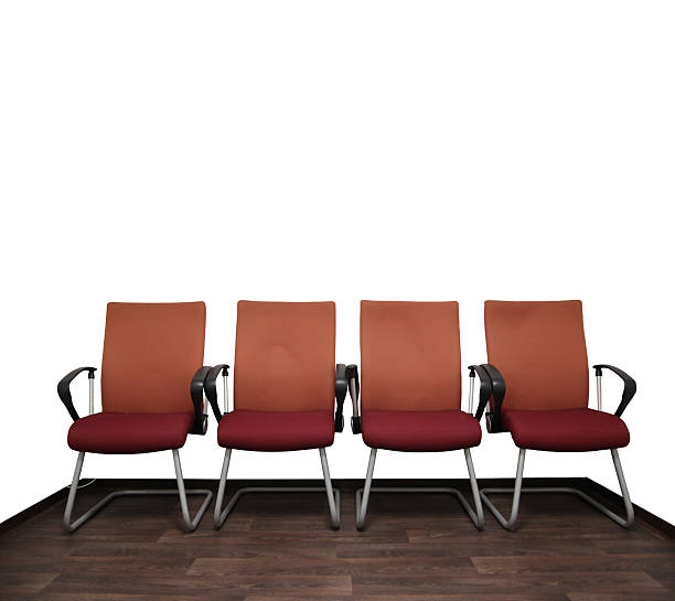 Four textile chairs in a row standing on dark laminate floor, isolated on white