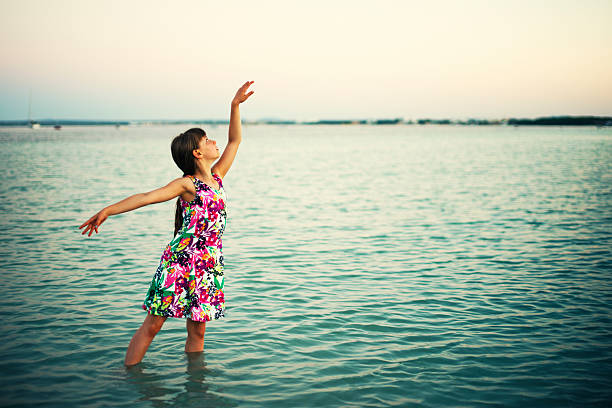 niña pequeña baile en el mar - wading child beach sundress fotografías e imágenes de stock