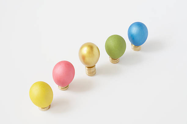 istock Colorful eggs put on pile of gold coins white background 540237346