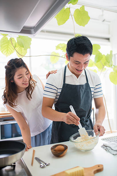 junges paar kochen zusammen - kyoto protokoll stock-fotos und bilder