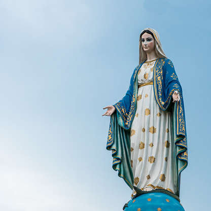 The virgin mary statue in blue sky background