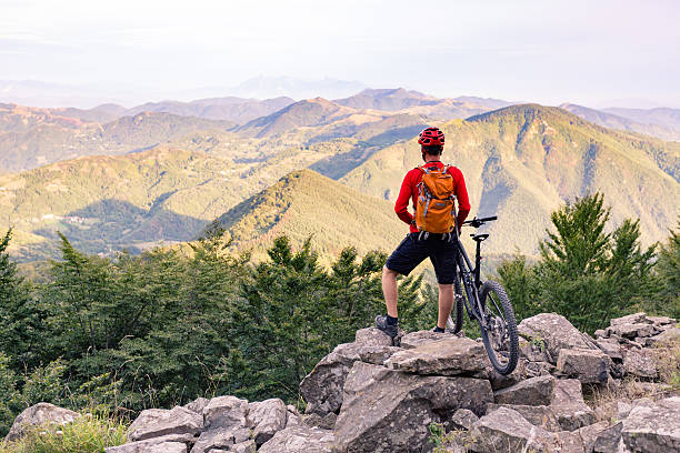 ciclista de montaña mirando a la vista en las montañas de otoño - action off road vehicle motocross cycle fotografías e imágenes de stock