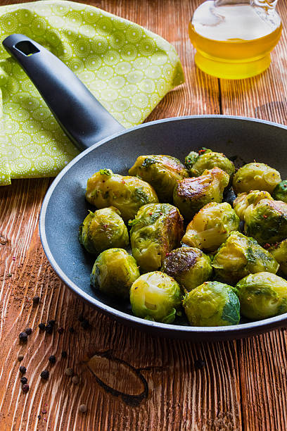 istock Fried brussels sprouts in a pan on the wooden background. 540240312