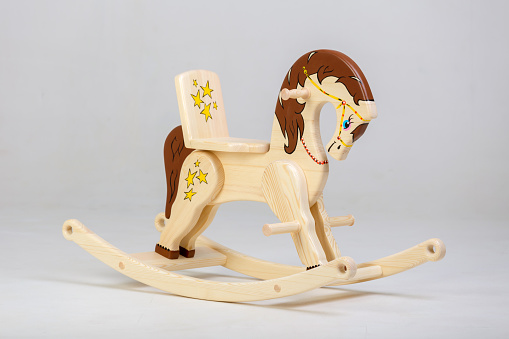 The  wooden rocking horse painted with floral patterns. Studio shooting on white background