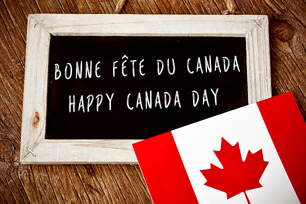 text Happy Canada Day in French and English the text Happy Canada Day written in French and English in a chalkboard, and a flag of Canada, on a rustic wooden surface canada day photos stock pictures, royalty-free photos & images