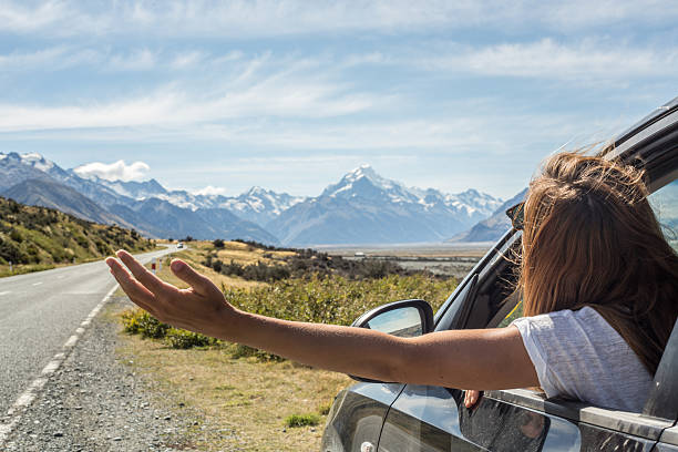 Female in car on roadside stretches arms out of window Young woman in a car on the roadside stretches arms out of window.  canterbury england stock pictures, royalty-free photos & images
