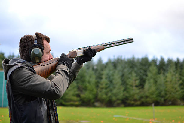 mann schießen tontauben im freien shotguns im - trefferversuch stock-fotos und bilder