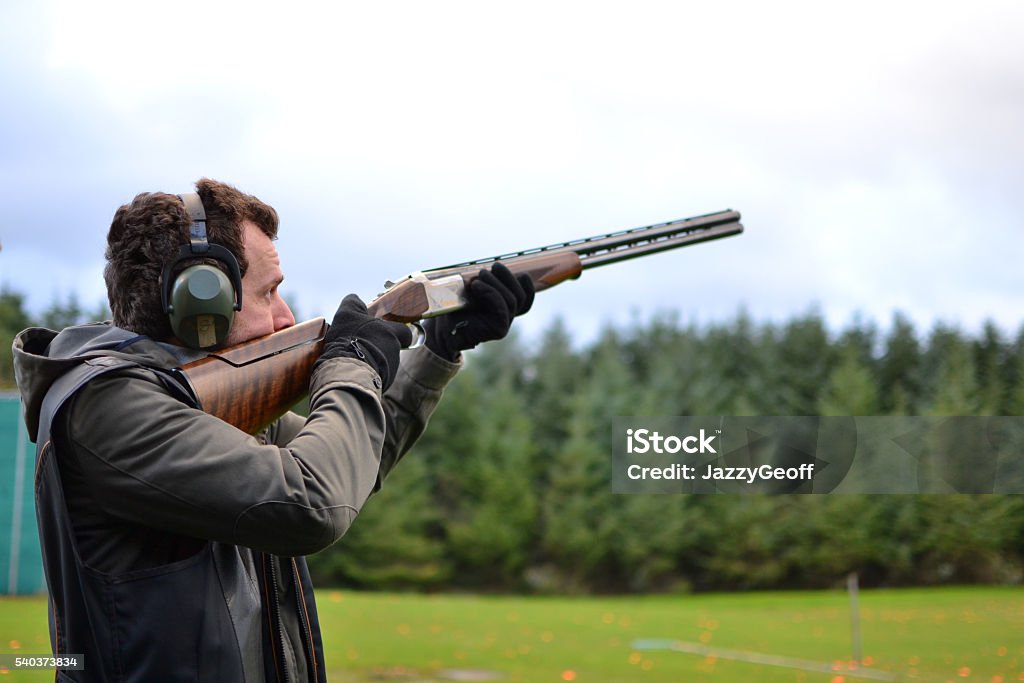 homme tir au pigeon d "argile shotguns en plein air - Photo de Tir à l'arme à feu libre de droits