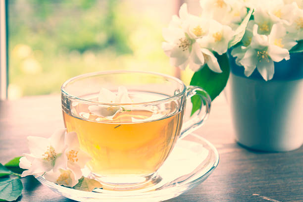 istock Cup of tea with jasmine and blooming jasmine branch 540373908