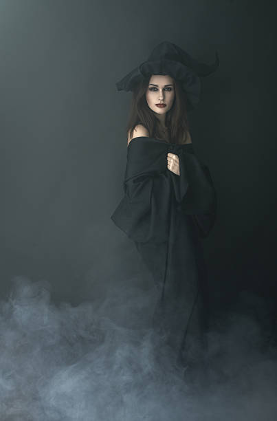 istock slender witch in a smoke on  black background 540377582