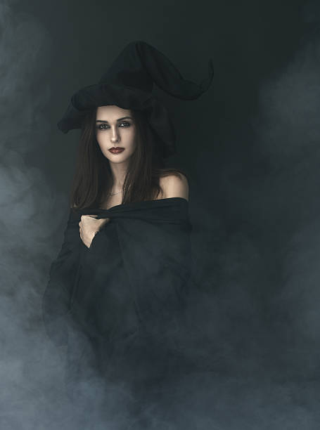 istock slender witch in a smoke on  black background 540378136