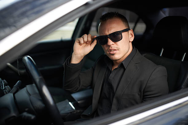 istock businessman stopped  car and adjusts glasses 540384734