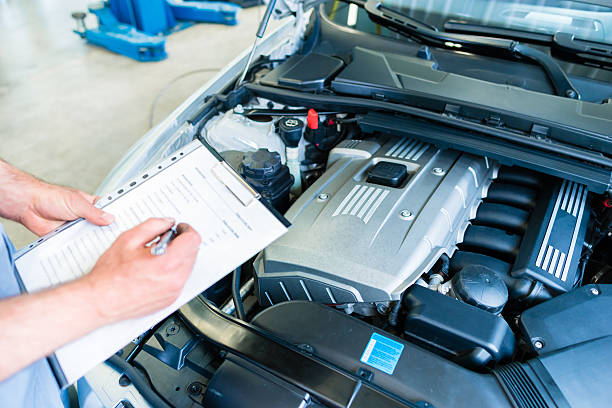 Mechanic with checklist in car workshop stock photo
