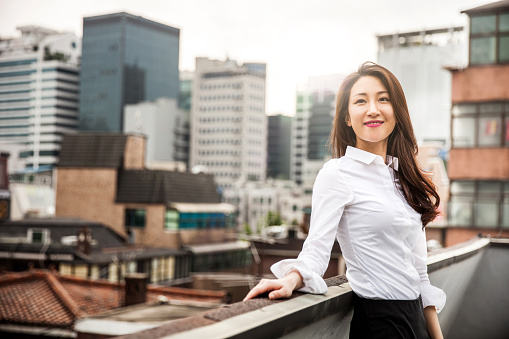 Smiling young business woman in Seoul downtown, South Korea.