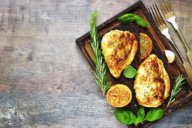 Grilled spicy chicken breast with herbs. Grilled spicy chicken breast with herbs on old cutting board.Food background.Top view. turkey breast stock pictures, royalty-free photos & images