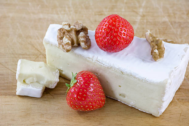 istock Brie cheese with walnuts and strawberries on wooden background 540394866