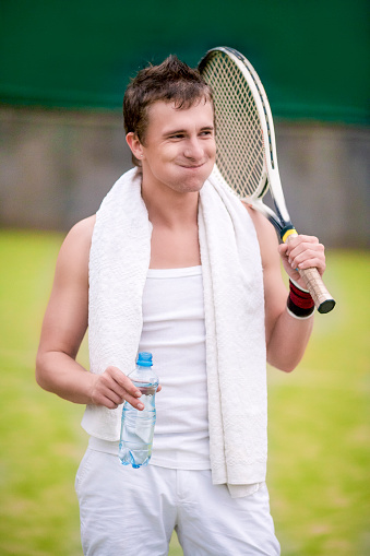 Professional Male Tennis Player Having WaterBrake on Court. Vertical Image Orientation