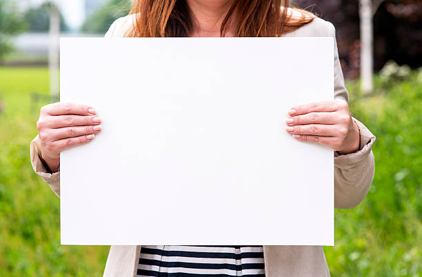istock woman outside with a blank white card 540395934