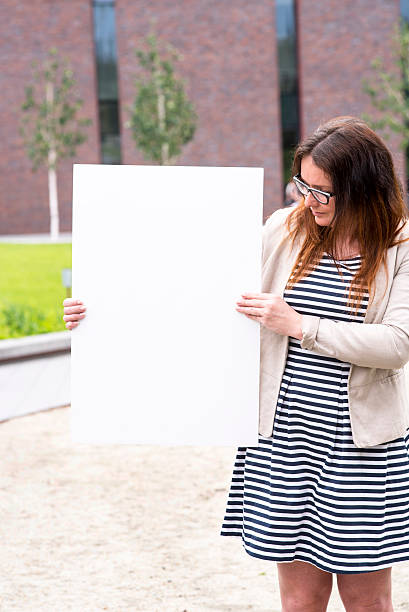 istock woman outside with a blank white card 540396074