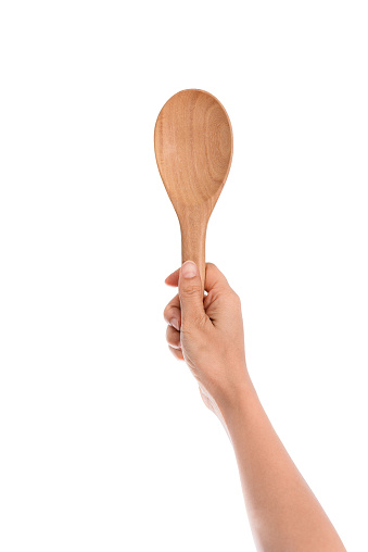 Woman Hand holding a wooden kitchen spoon for stirring and tasting food in the kitchen, isolated on white background with clipping path